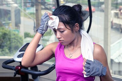 Woman wiping sweat off head