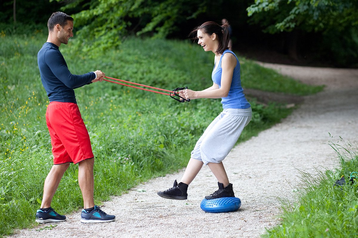 trainer and client resistance band exercises outdoors